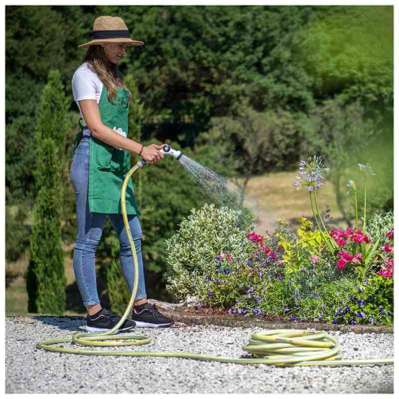 Mujer usando la manguera Fitt Nts Yellow para regar su jardín